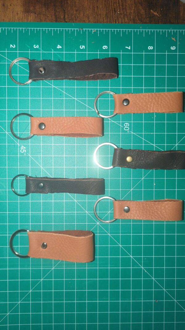 Tan and Dark colored short deer hide keychains.